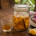 Rhum arrangé ananas et vanille en bocal, avec un verre servi et une gousse de vanille