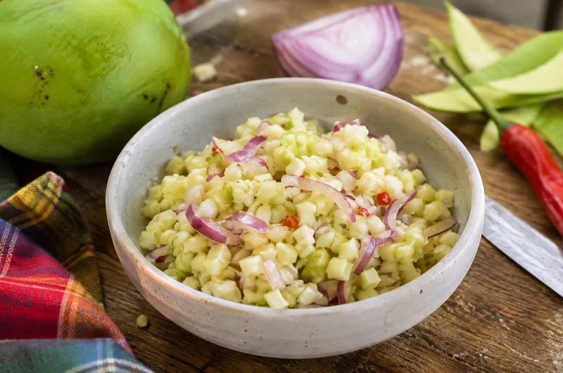 Rougail mangue verte fraîchement préparé dans un bol, avec oignon rouge et piment