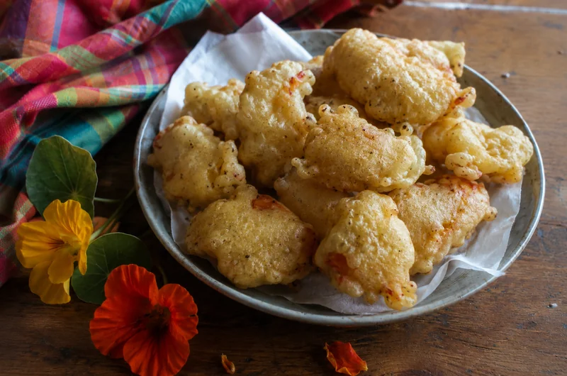 Beignets de fleurs de capucine croustillants servis avec des fleurs fraîches
