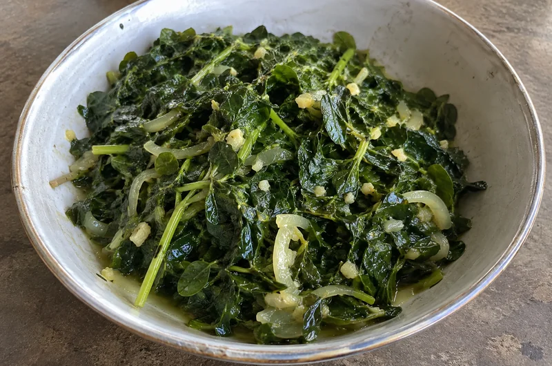 Bouillon de brèdes mouroungue (moringa) dans un bol, feuilles mijotées à l'ail, au gingembre et à l'oignon