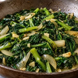 Fricassée de brède morelle (brède martin) sautée à l'ail et à l'oignon dans une poêle