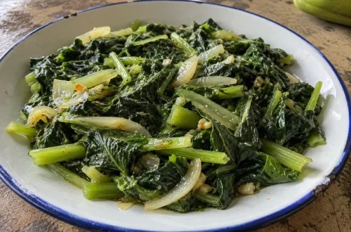 Fricassée de brèdes chouchou dans une assiette, feuilles et tiges sautées à l'ail et à l'oignon