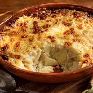 Gratin de fruit à pain gratiné au fromage dans un plat en terre cuite