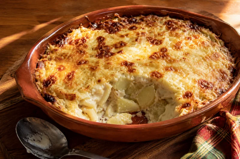Gratin de fruit à pain gratiné au fromage dans un plat en terre cuite