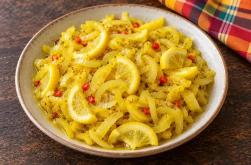 Achards de citrons réunionnais dans un bol en grès : lamelles de citron, oignon et piment rouge dorés au curcuma