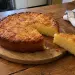 Gâteau manioc réunionnais doré sur une planche en bois, une part coupée montrant sa mie dense et fondante