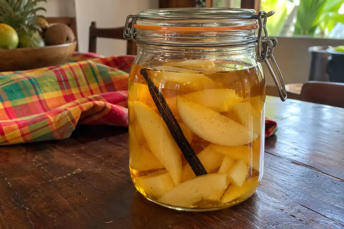 Bocal de rhum arrangé poire vanille : quartiers de poire épluchés et gousse de vanille dans un rhum doré