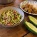 Bol de rougail margoze : fines lamelles de margoze crue, oignon rouge et piment, à côté d'une margoze coupée en deux et d'une assiette de cari et riz
