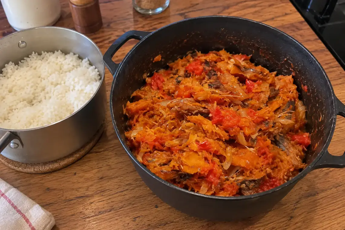 Marmite en fonte de rougail sounouk : poisson fumé effiloché et doré dans une sauce tomate aux oignons, casserole de riz blanc à côté