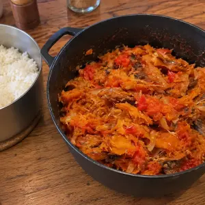 Marmite en fonte de rougail sounouk : poisson fumé effiloché et doré dans une sauce tomate aux oignons, casserole de riz blanc à côté