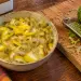 Bol de rougail citron réunionnais, citron jaune coupé avec sa peau, oignon rouge et piment vert, à côté d'un combava à moitié râpé sur une planche