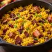 Marmite en fonte de zembrocal réunionnais : riz jaune au curcuma, haricots rouges entiers et cubes de boucané dorés, parsemés d'oignons verts
